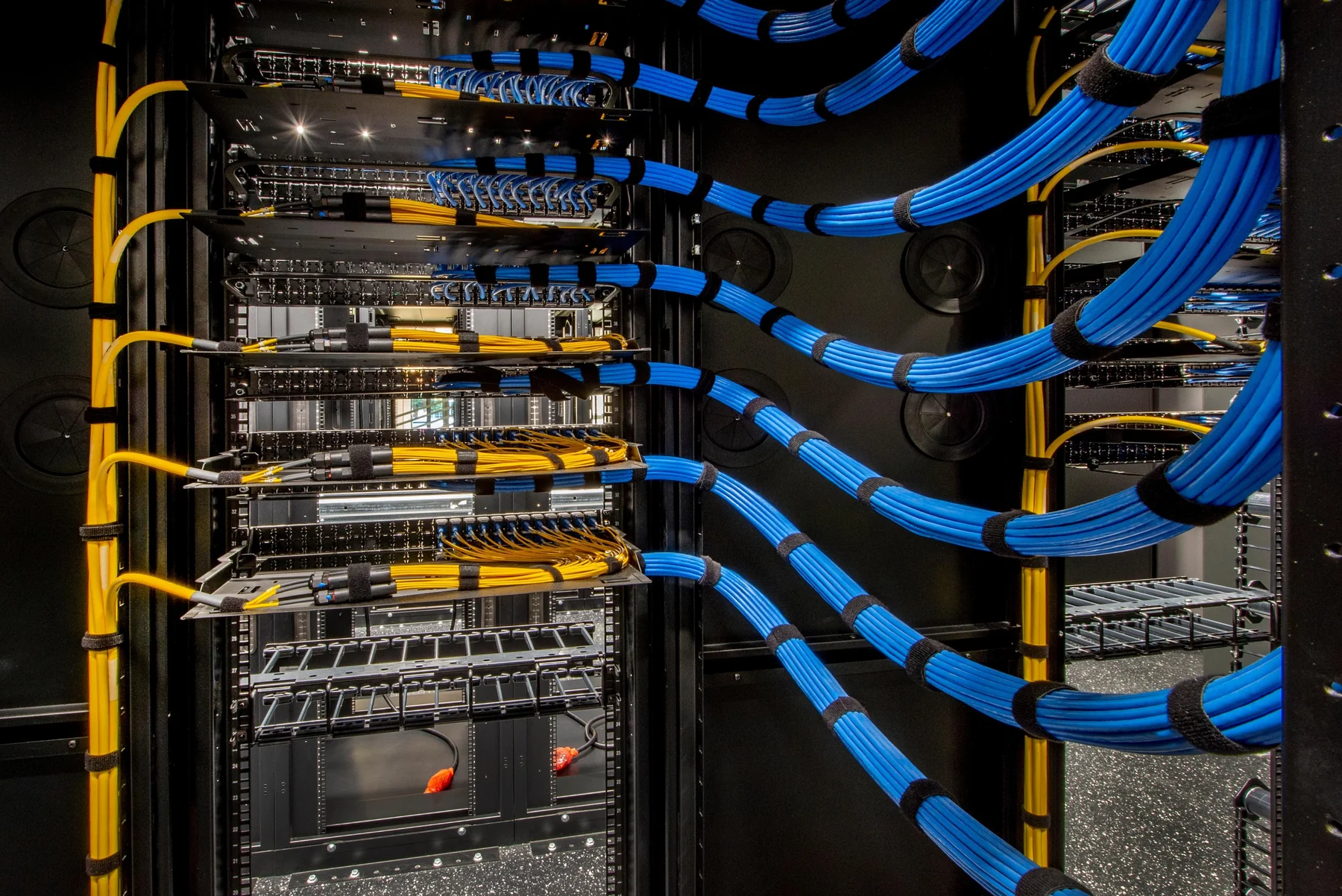 Organized server room networking rack with structured blue cabling